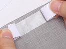 hands putting body tape on a piece of clothing