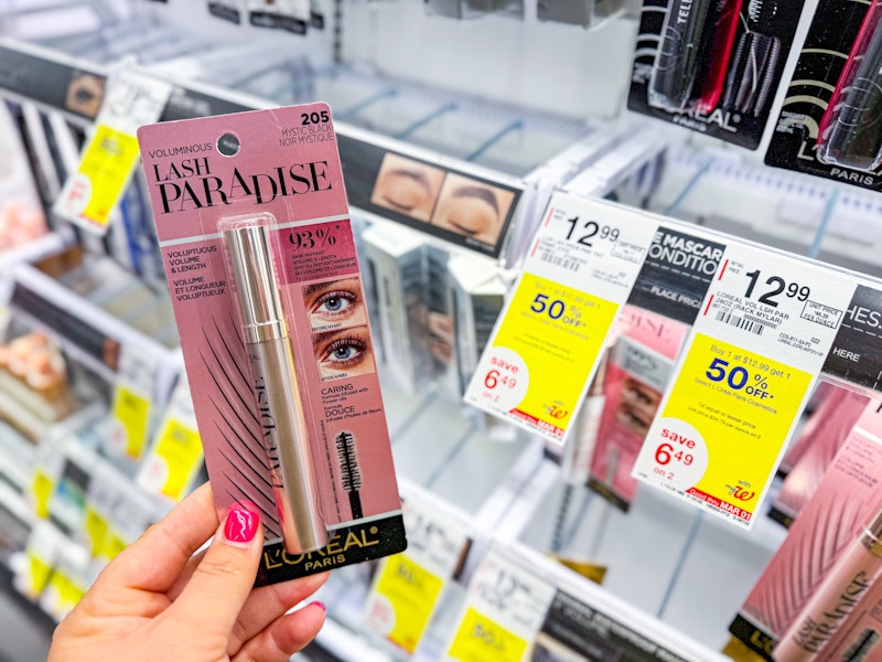 person holding loreal lash paradise mascara by a display