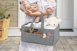 woman carrying diaper caddy and baby