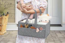 woman carrying diaper caddy and baby