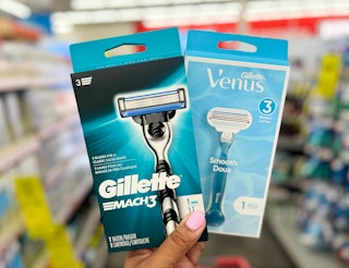 hand holding one box of Gillette Mach3 and Gillette Venus Smooth razors in aisle