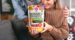 a person holding a bag of flower seed mix 