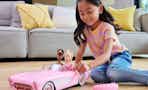 a child playing with a Barbie corvette