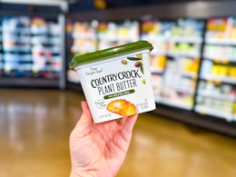 hand holding a tub of country crock plant butter