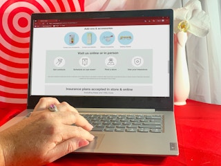 hand on laptop looking at target optical website