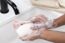 person washing their hands with bar soap