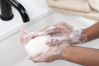 person washing their hands with bar soap