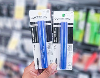 hand holding two Covergirl mascaras