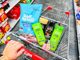 hand pushing shopping cart with products inside