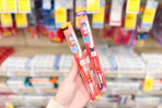 person holding 2 cvs health toothbrushes