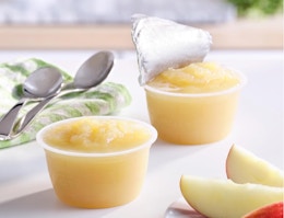 cups of applesauce on a table with spoons