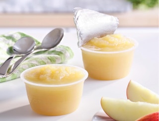 cups of applesauce on a table with spoons