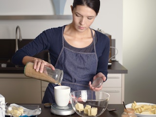 person surrounded by ingredients baking in the kitchen