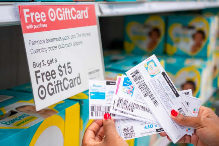 Pampers diaper coupons next to a Free GiftCard sign inside Target.