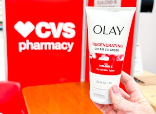 person holding olay cleanser by a cvs sign