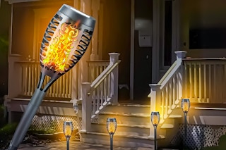 Lifestyle image of Sennachine Solar Torch Lights used outdoors at night to illuminate porch