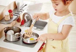 child playing with the Hape Kitchen Set