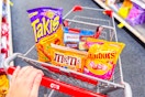 person pushing a cart with takis and candy in it