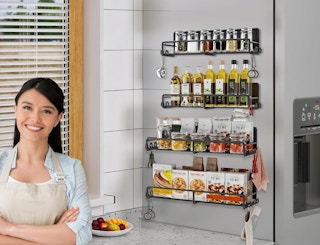 a spice rack with spices and oils on the side of a fridge 