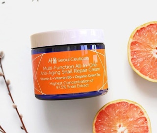 repair cream in a jar on a table with orange slices