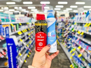 hand holding two spray deodorants