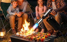 a person using a torch on a grill outside 