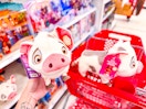 hand holding a disney moana walk & snort pua plush in front of target cart