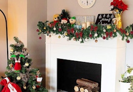 Christmas garland on a mantle next to a Christmas tree