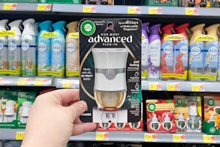 Air Wick Advanced Warmer held in front of other air fresheners in Walmart