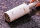 a lint roller being rolled on a sweater