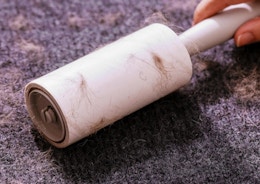 a lint roller being rolled on a sweater
