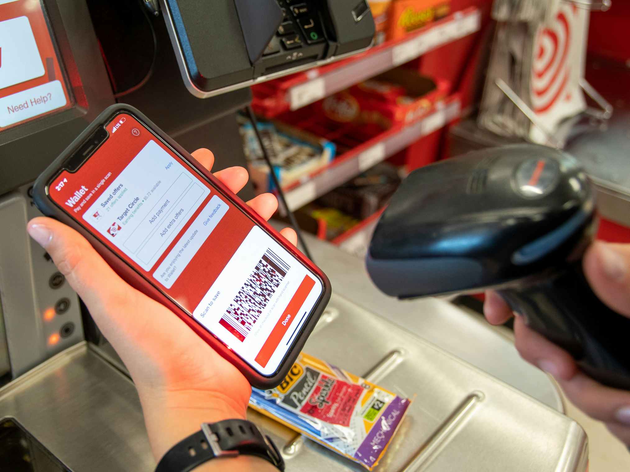 A woman scanning her Circle barcode in the Target app at a self-checkout register in the store.