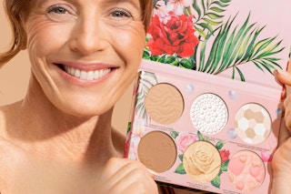 woman holding palette next to face and smiling