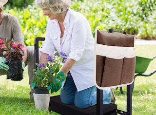 a woman kneeling on a seating while gardening with a man