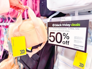 hand holding an all in motion mini duffle bag in front of target signage