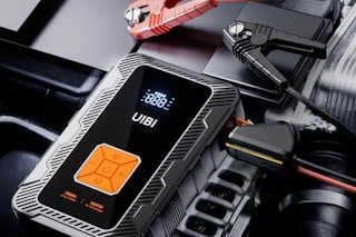 UIBI X7 Jump Starter with Air Compressor sitting on an engine.