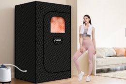 Woman standing next to the CUEME Sauna Box in her home.