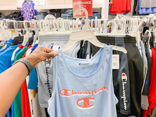 someone holding a shirt in front of a clearance section
