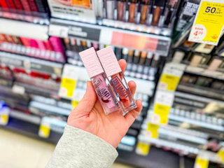 hand holding maybelline lifter plumping gloss in walgreens