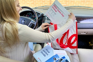 a woman looking at a walgreens photo order in car