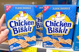 hand touching a box of chicken in a biskit crackers