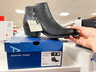 boot held over shoe box in store