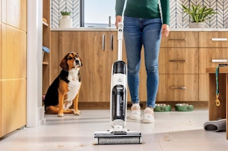 a woman cleaning the floor with a bissell cleaner