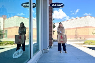 a woman standing outside old navy with bag and receipt