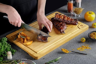 a man cutting meat on a cutting board