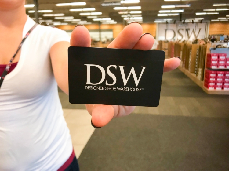 Person holding DSW gift card in DSW store