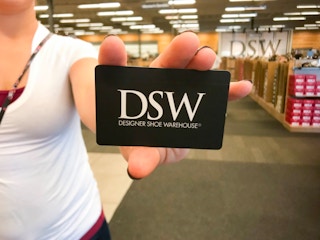 Person holding DSW gift card in DSW store