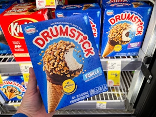 hand holding box of cones in front of freezer shelves