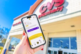 hand holding a smartphone displaying a kcl app 1-clip deal outside of a cvs store