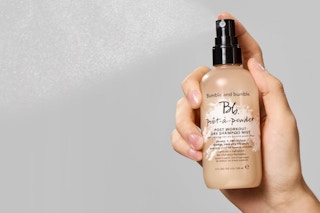 a brown bottle of dry shampoo being sprayed